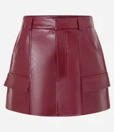 Short pollera de cuero sintético color bordó, con bolsillos delanteros con solapa y cierre frontal con cremallera.