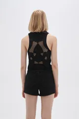 Musculosa negra calada sin mangas, ajustada al cuerpo y con cuello a la base.