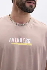 Remera de manga corta color taupe con un gran estampado en la espalda del logo de los Avengers y el texto "The Battle Begins".