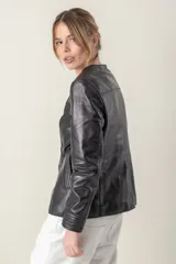 Campera azul de cuero ovino italiano, con cuello redondo, cierre frontal con broches ocultos, bolsillos laterales y detalle de capitoneado en puños y bolsillos.