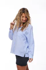 Camisa celeste de manga larga con cuello clásico y bolsillo en el pecho.