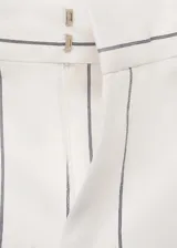 Pantalón de vestir de tiro medio, color blanco con rayas verticales negras, de corte wide leg y largo hasta el tobillo. Cierre frontal con botón, gancho y cremallera oculta. Con bolsillos laterales y trabillas para cinturón.