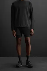 Shorts de running negros con malla interior, cintura elástica ajustable con cordón, bolsillo trasero con cierre, bolsillo multifunción en la malla interior, perneras perforadas, bajo termofijado, aberturas laterales y logo estampado.