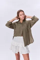 Camisa verde militar de manga larga con dos bolsillos frontales con solapa y cierre con botones.