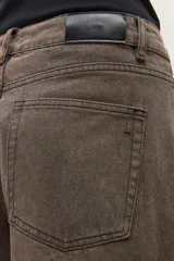 Pantalón de jean estilo barrel, color marrón oscuro con efecto desgastado. Presenta un calce holgado y tiro alto.