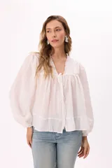 Blusa blanca de mangas largas abullonadas, con escote en V con lazo y volados.