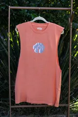Musculosa color salmón con cuello redondo y sisa amplia. Estampado en el centro del pecho con diseño abstracto en forma circular en tonos gris y blanco.