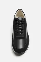 Zapatilla deportiva negra con detalles en piel y acabado serraje.