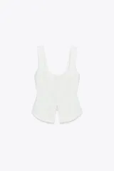 Top blanco de escote pico y tirantes anchos con detalle de picueta a tono y abertura en el bajo.