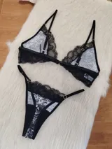 Conjunto de lencería compuesto por un corpiño triangular sin aro con estampado animal print y detalles de encaje negro, y una bombacha tipo colaless con el mismo estampado y borde de encaje negro. El corpiño tiene cierre frontal.