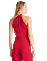 Enterito largo de crepe color rojo, con escote halter anudado y pierna ancha. Presenta bolsillos delanteros y abertura en la espalda con cierre invisible y botón.