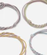 Set de cuatro gomitas de pelo elásticas con diseño trenzado en colores pastel: rosa, verde, amarillo y celeste.