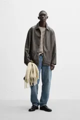 Pantalón de jean gris de corte recto, con cinco bolsillos, efecto lavado y cierre frontal con botones.