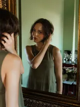 Vestido tejido color verde oliva, sin mangas y con cuello redondo. Presenta espalda descubierta con lazos.