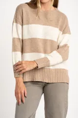 Sweater de punto con diseño de rayas horizontales anchas, alternando color beige camel y blanco roto con motas de color. Presenta cuello redondo y puños y borde inferior acanalados.