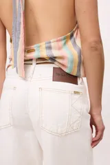 Pantalón de jean crudo, de corte recto y tiro bajo, con doble pasacinto y ajuste con lazo.