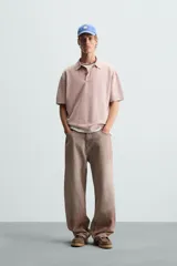 Polo de hombre color rosa, corte relaxed fit, tejido de punto con textura bouclé y mezcla de algodón. Tiene cuello solapa, cierre frontal con botones, manga corta y acabados en rib.