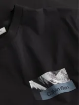 Remera negra de algodón regenerado con cuello redondo, mangas cortas y estampado gráfico con logo de Calvin Klein en el pecho.