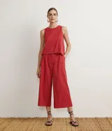 Blusa musculosa color ladrillo en tejido de laise texturizado, con cuello redondo, tirantes anchos y aplicación de canutillos de madera en la barra.