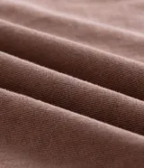 Remera masculina color marrón con efecto desgastado, de corte boxy y mangas cortas. Presenta un estampado frontal en blanco con el texto "London Street Unit" y un globo terráqueo.