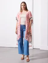 Kimono tejido con estampado abstracto en tonos beige, blanco y negro. Tiene mangas amplias estilo japonés y terminación de ruedo con borlas.