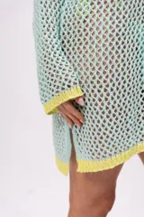 Vestido corto de red color celeste con terminaciones en amarillo.