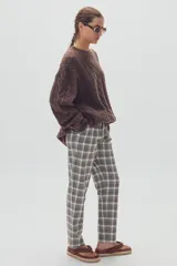 Pantalón de vestir de corte recto con estampado de cuadros escoceses en tonos grises, blancos y marrones.