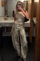 Pantalón de jean de tiro alto con estampado abstracto en tonos beige y marrón.
