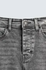 Pantalón de jean negro ajustado al cuerpo desde la cintura hasta el tobillo, de tiro medio y tejido elástico. Diseño de cinco bolsillos con lavado efecto roto y cierre frontal con cremallera y botón.