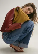 Pantalón de jean azul de corte wide leg, tiro medio, con cierre de cremallera y botón, bajo con dobladillo y cinco bolsillos.