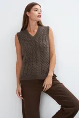 Chaleco tejido color beige con escote en V y diseño de punto trenzado.