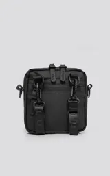 Mini bolso negro de estilo modular, confeccionado en tejido tracker impermeable. Presenta tres compartimentos con cierre y correa ajustable para llevar al hombro o cruzado.