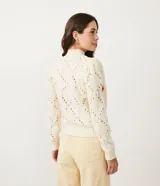 Suéter de punto color crema con cuello alto, textura de pompones y bordados florales.