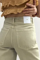 Jeans color verde claro de tiro alto, corte recto y largo tobillero. Diseño de cinco bolsillos y cierre frontal con cremallera y botón metálico.