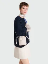 Bolso bandolera XS de cuero color crema, con cierre de cordón ajustable y solapa con botón a presión.