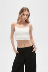 Musculosa blanca de algodón con breteles finos, punto smock, corte al cuerpo y cuello redondo.
