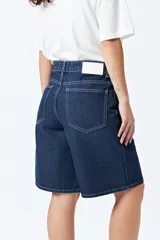 Bermuda de denim azul oscuro, con fit relajado y largo a la rodilla.