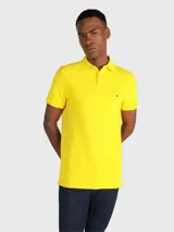 Chomba amarilla de corte regular, con cuello tipo polo y diseño de rayas, detalles distintivos de Tommy Hilfiger.