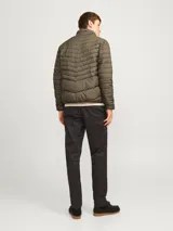 Campera puffer color verde oliva, con cuello alto y cierre frontal con cremallera. Tiene bolsillos laterales y puños elásticos.