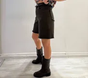 Bermuda marrón de gabardina elastizada con cinturón fino con tachas y detalles de flecos en el ruedo.