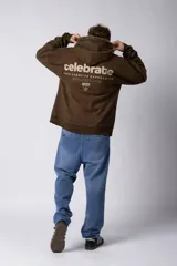 Buzo canguro negro de frisa rústica con corte oversize y capucha. Presenta un pequeño logo blanco en el pecho y un bolsillo tipo canguro.