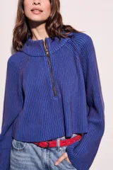 Sweater azul de tejido de punto acanalado, con cuello polo y cierre frontal parcial.