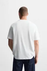 Camiseta blanca de cuello redondo y manga corta, corte regular.