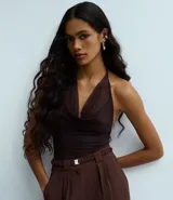 Body color marrón oscuro, de frente única, confeccionado en tul con escote drapeado (degagê) y espalda abierta. Tiene cierre en la entrepierna y forro.