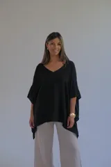 Blusa negra de diseño oversize con caída suave y mangas amplias.