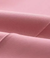 Conjunto de sastrería color rosa, compuesto por un blazer cruzado de corte holgado y un pantalón de vestir tiro alto, corte carrot con pinzas y puños doblados.