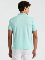 Polo de piqué color celeste con cuello clásico, tapeta de dos botones y logo bordado en el pecho. Detalles de ribete en cuello y mangas.