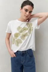 Remera blanca de manga corta con estampado floral en tonos dorados en el frente.