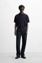 Jeans de corte slim fit confeccionados en denim de algodón sin lavados, color azul oscuro. Cierre frontal con botones y cinco bolsillos.