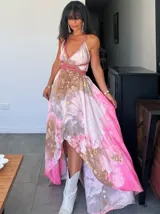 Vestido largo de tela fluida, color verde esmeralda con estampado abstracto en tonos turquesa y detalles dorados. Diseño asimétrico con un solo tirante tejido en el hombro.